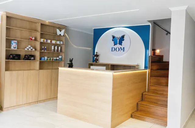 Recepção do DOM Centro Veterinário, com balcão e logotipo na parede